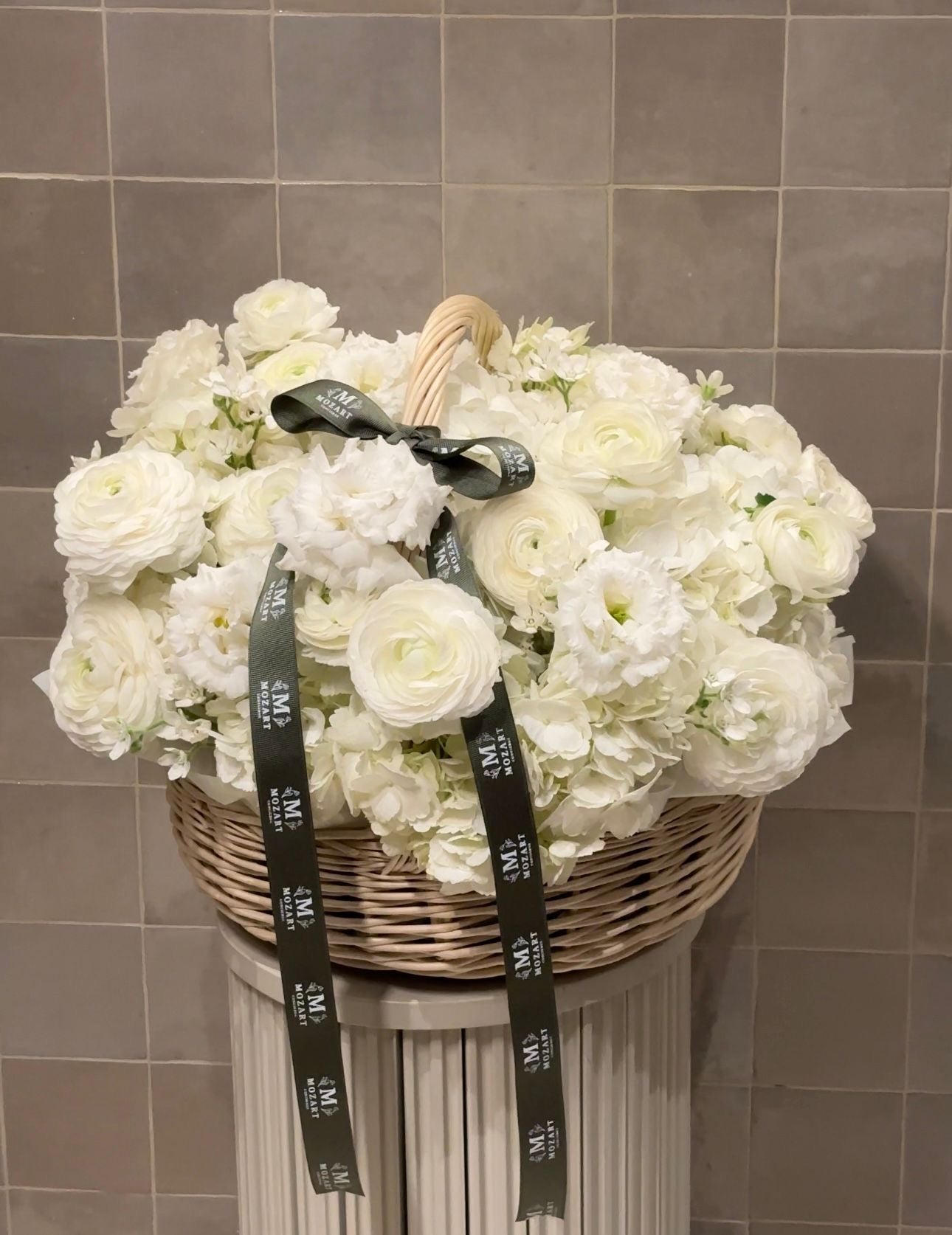 Elegant all-white flower arrangement in a basket, perfect for timeless and minimal gifting